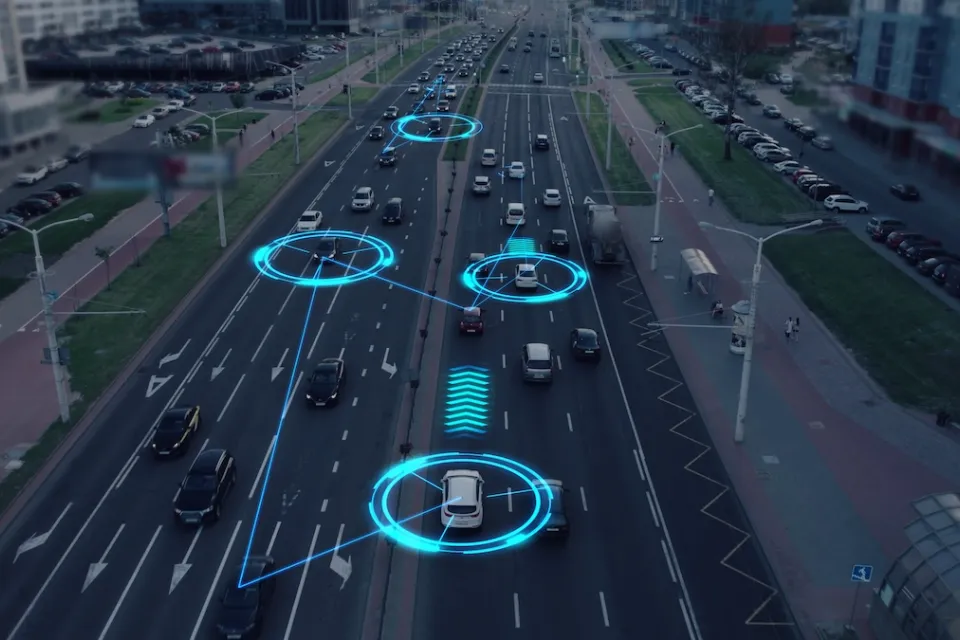 Image of cars driving on multi-lane road with graphics indicating the vehicles are communicating with each other.